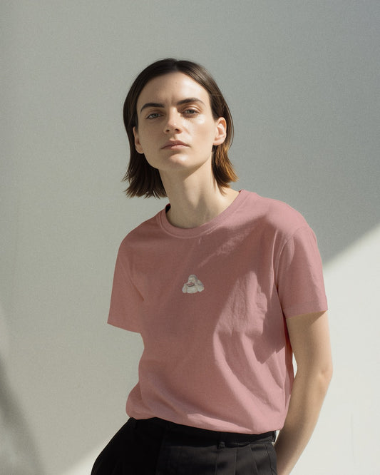 Person wearing a pink t-shirt with a small graphic of Geoff eating a watermelon on a plain background. T-shirt is of the brand Geoff & Jeffrey.