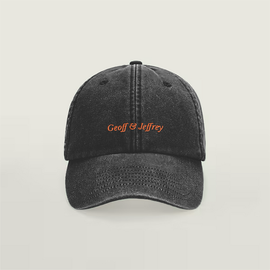 Front view of Geoff & Jeffrey vintage black dad cap with orange embroidery