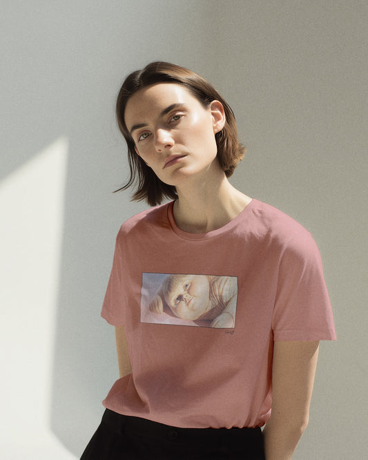 Front view of a light pink organic cotton t-shirt featuring a close-up, half-frame graphic print of a jolly, proud boy (Geoff) looking slightly upwards, with his name 'Geoff' subtly printed below the image. The t-shirt has a dreamy aesthetic.