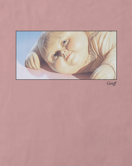 light pink organic cotton t-shirt featuring a close-up, half-frame graphic print of a jolly, proud boy (Geoff) looking slightly upwards, with his name 'Geoff' subtly printed below the image. The t-shirt has a dreamy aesthetic.