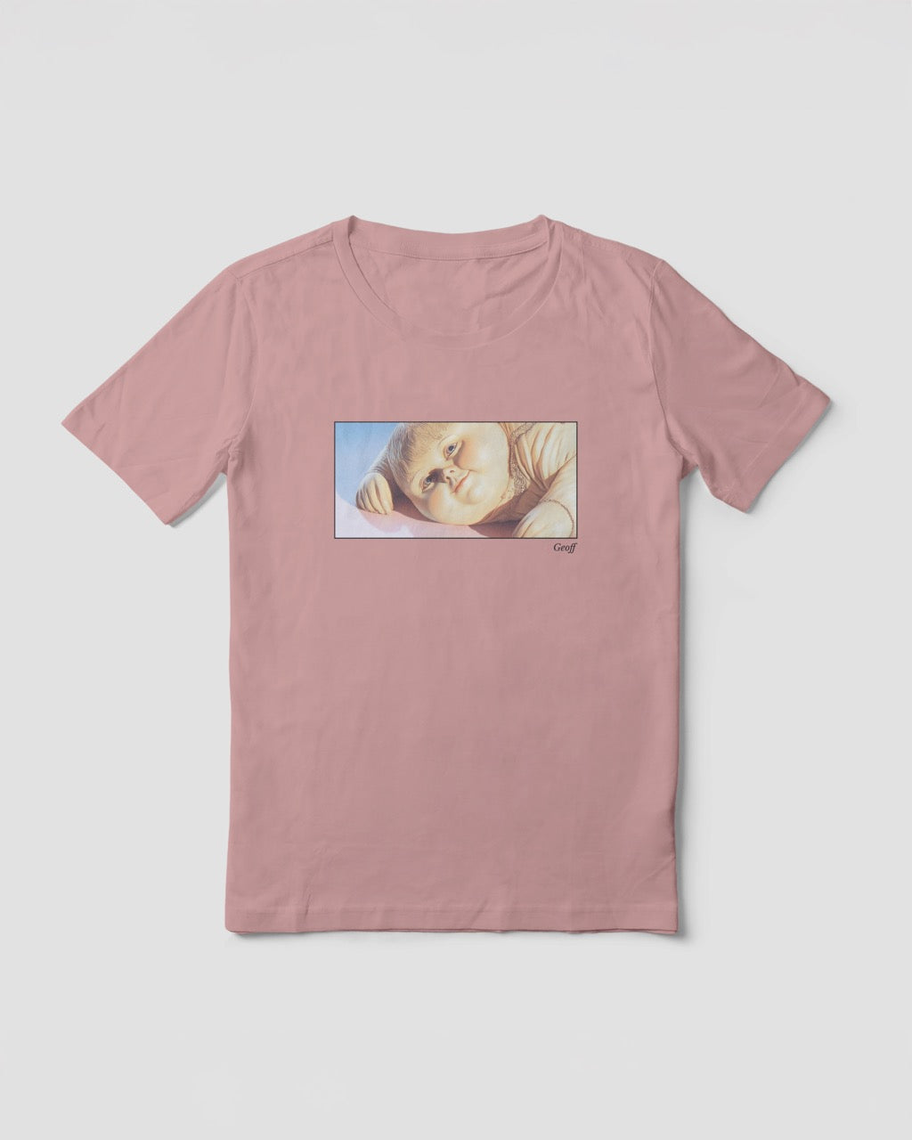  light pink organic cotton t-shirt featuring a close-up, half-frame graphic print of a jolly, proud boy (Geoff) looking slightly upwards, with his name 'Geoff' subtly printed below the image. The t-shirt has a dreamy aesthetic.