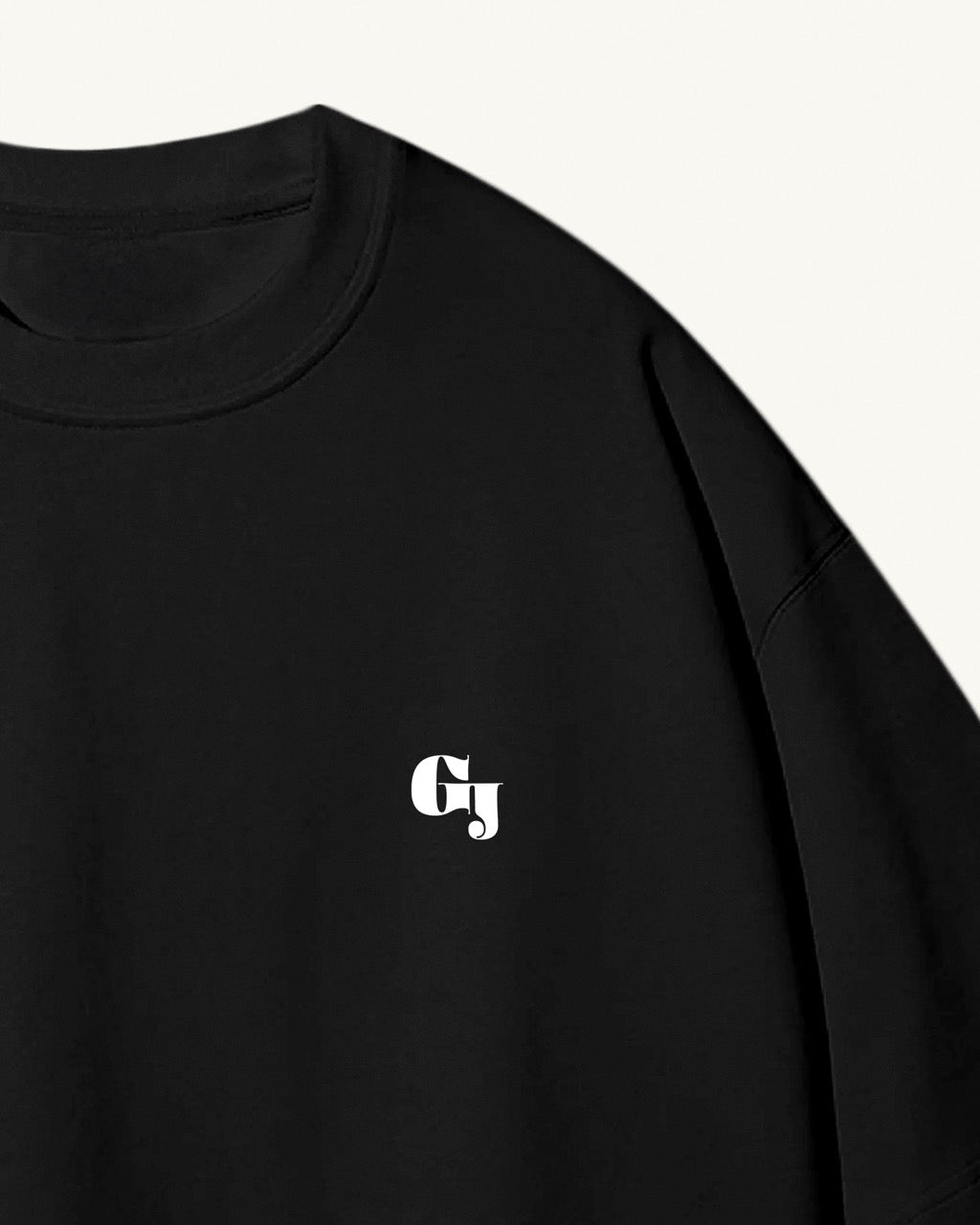 Close up of a men's black organic cotton Geoff & Jeffrey front of t-shirt with the brand logo. The t-shirt has a minimal design.