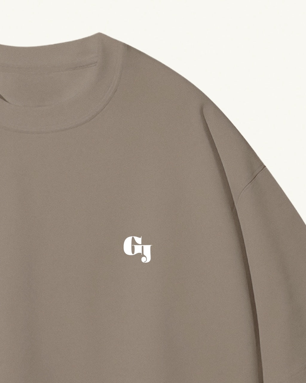 Close up of a men's light kaki / brown organic cotton Geoff & Jeffrey front of t-shirt with the brand logo. The t-shirt has a minimal design.