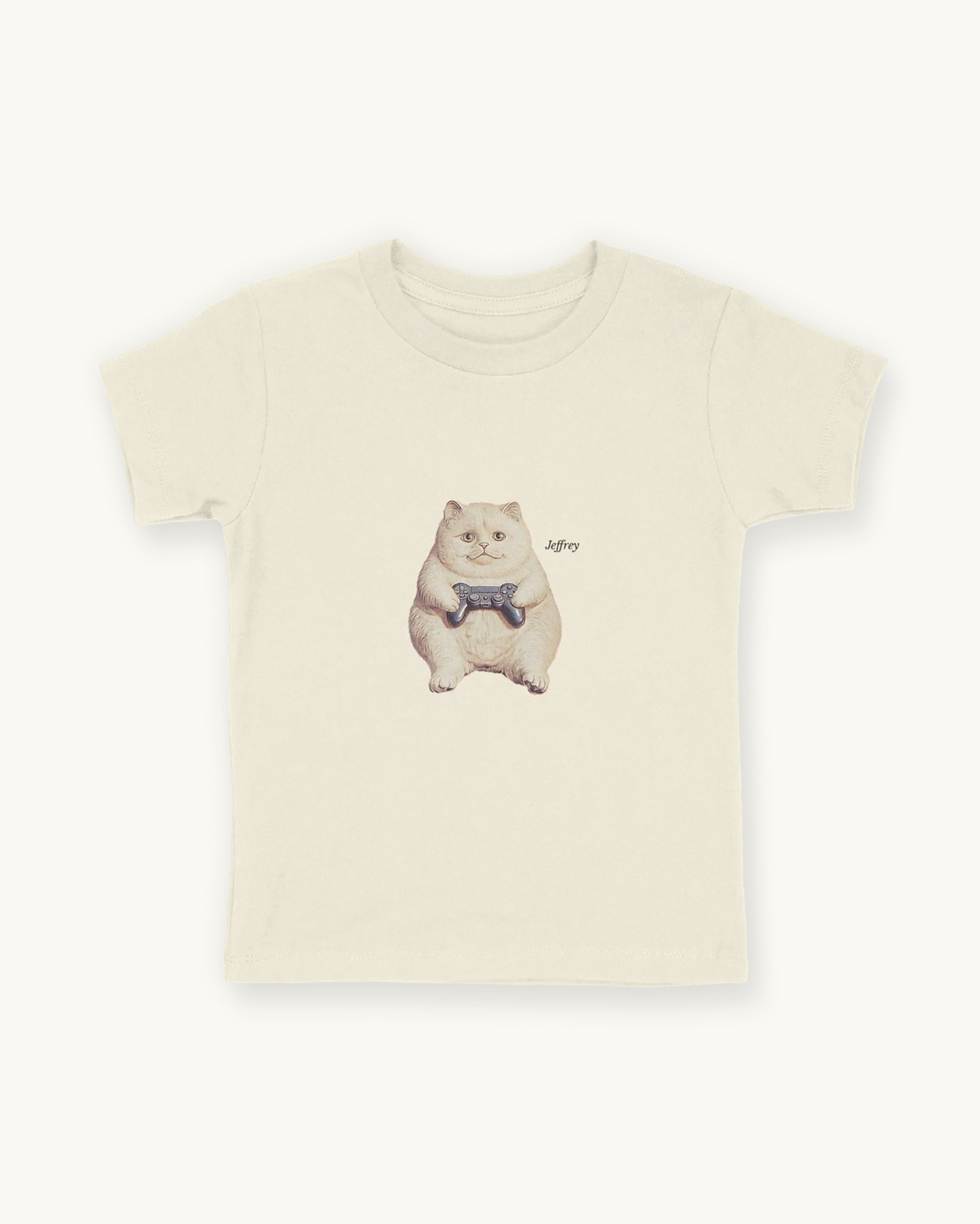 Fitted children's natural white tee with a front print cutout of the cat Jeffrey gaming with this name in Libre Baskerville.