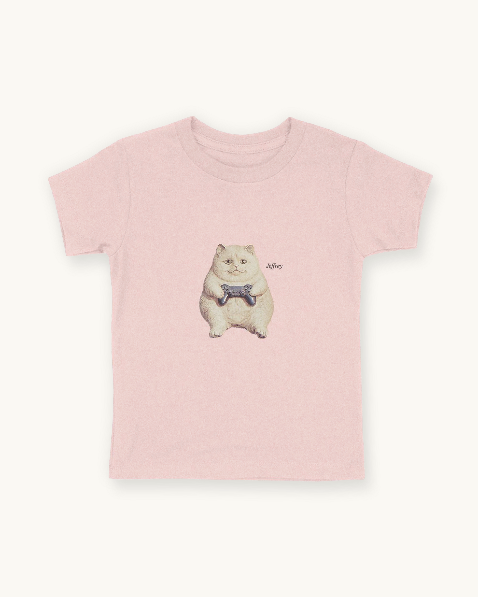 Fitted children's pink tee with a front print cutout of the cat Jeffrey gaming with this name in Libre Baskerville.