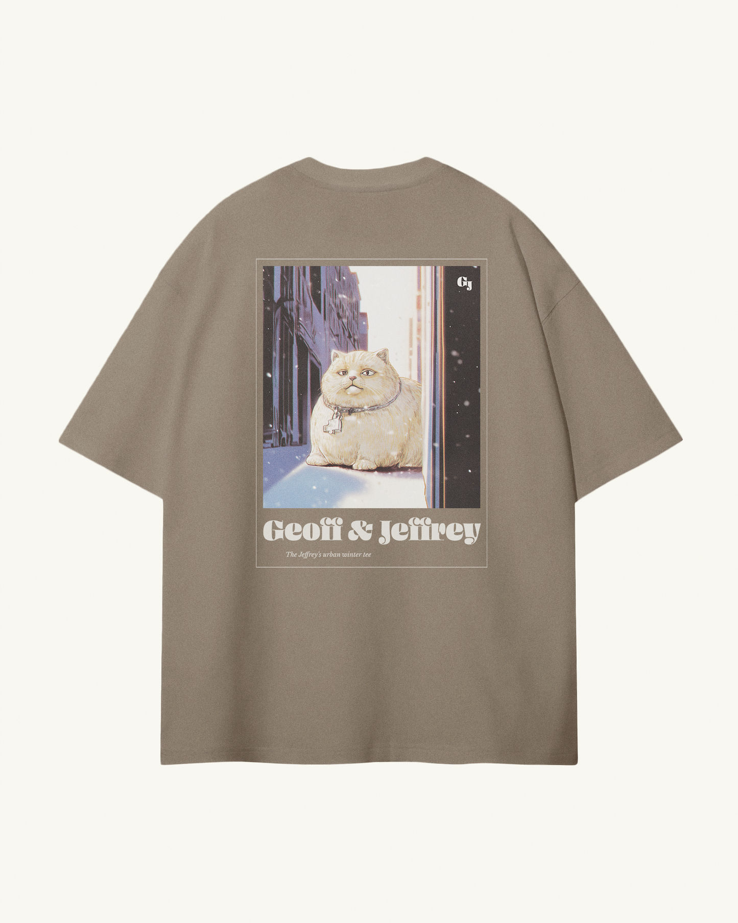 beige organic cotton Geoff & Jeffrey unisex tee with drop shoulders  and a large graphic backprint of a joyful, fat cat in the city with snow, with the brandname in ohno blazeface and title in libre baskerville printed below.