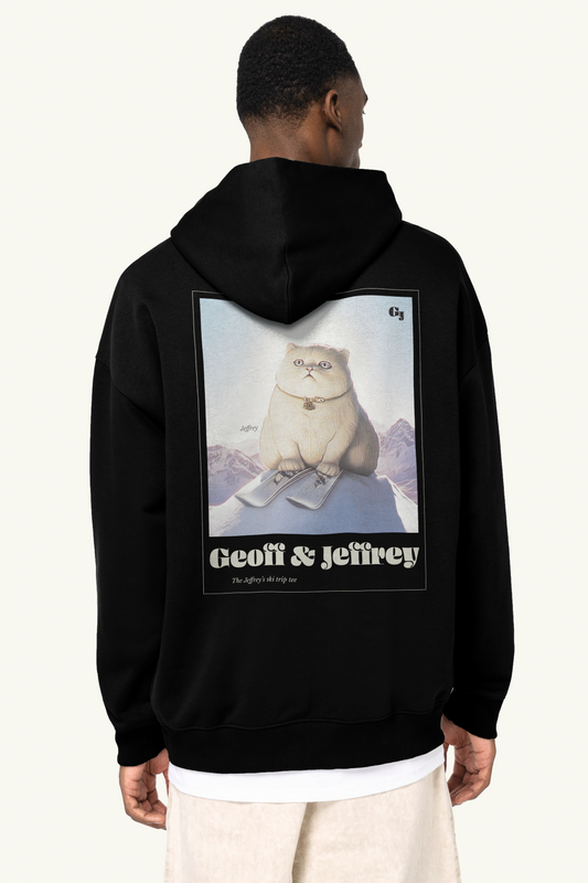 Person wearing a black hoodie with 'Geoff & Jeffrey' graphic on the back. The cute cat Jeffrey skiing