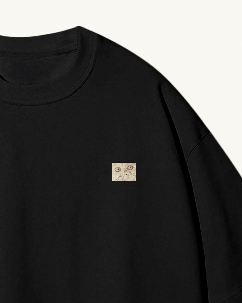 black organic cotton Geoff & Jeffrey unisex t-shirt with drop shoulders. The front of the shirt has a small close up of Jeffrey’s face and a minimal design.