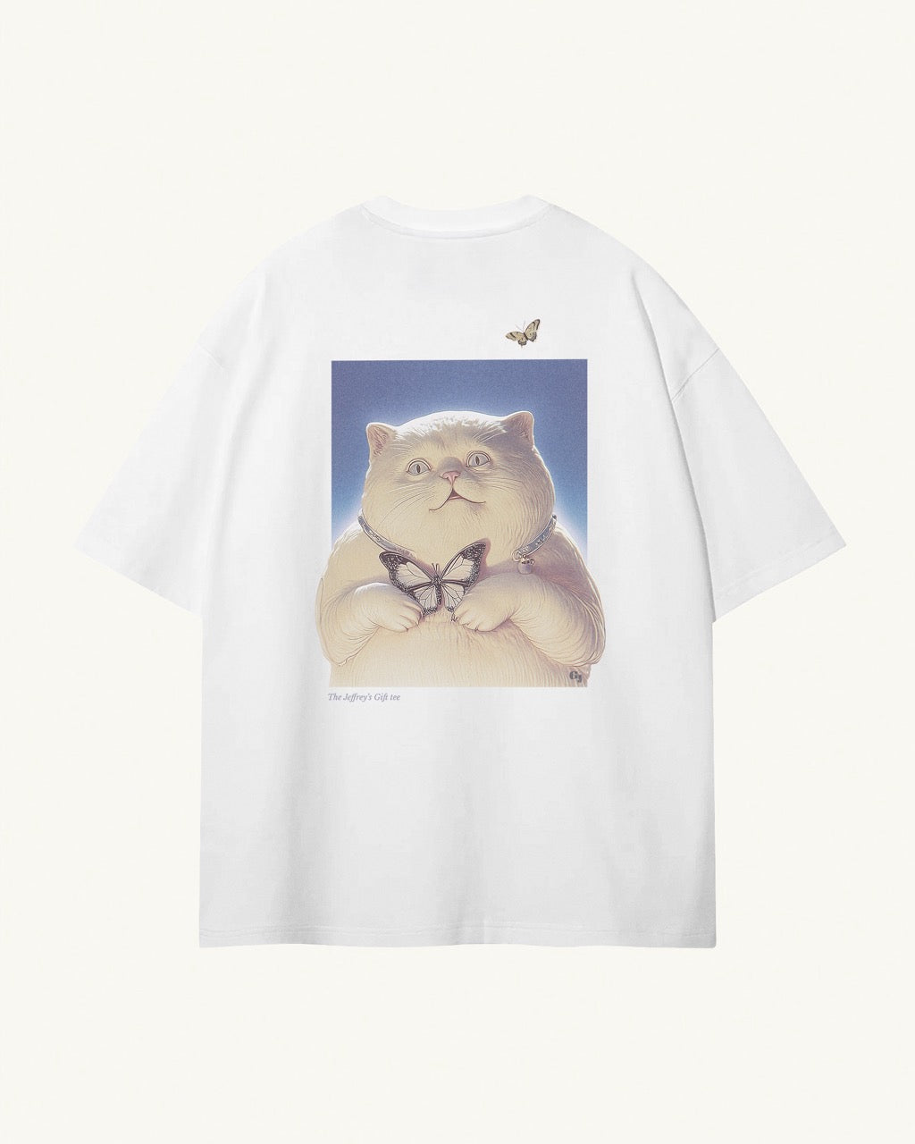 white organic cotton Geoff & Jeffrey unisex t-shirt with drop shoulders and a large graphic backprint of the cute cat Jeffrey holding a butterfly,with the title printed below. The shirt has a cool aesthetic.