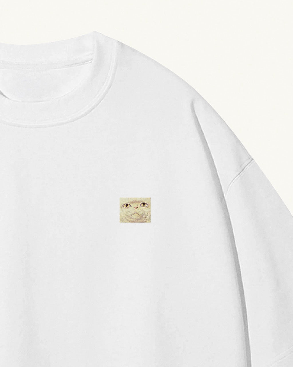 white organic cotton Geoff & Jeffrey unisex t-shirt with drop shoulders. The front of the shirt has a small close up of Jeffrey’s weird face and a minimal design.