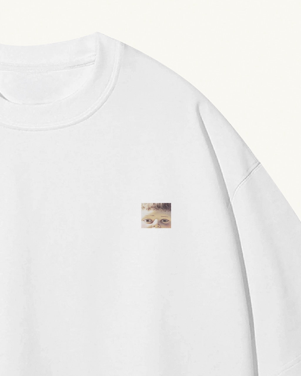 white organic cotton Geoff & Jeffrey unisex t-shirt with drop shoulders. The front of the shirt has a small close up of geoff’s face and a minimal design.