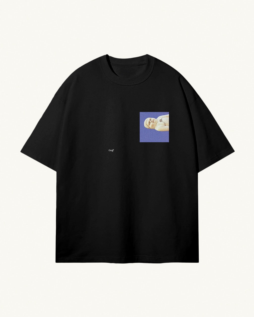 black organic cotton Geoff & Jeffrey, unisex t-shirt with drop shoulders and Geoff lying down on a blue square on the front. The shirt has a minimal design.
