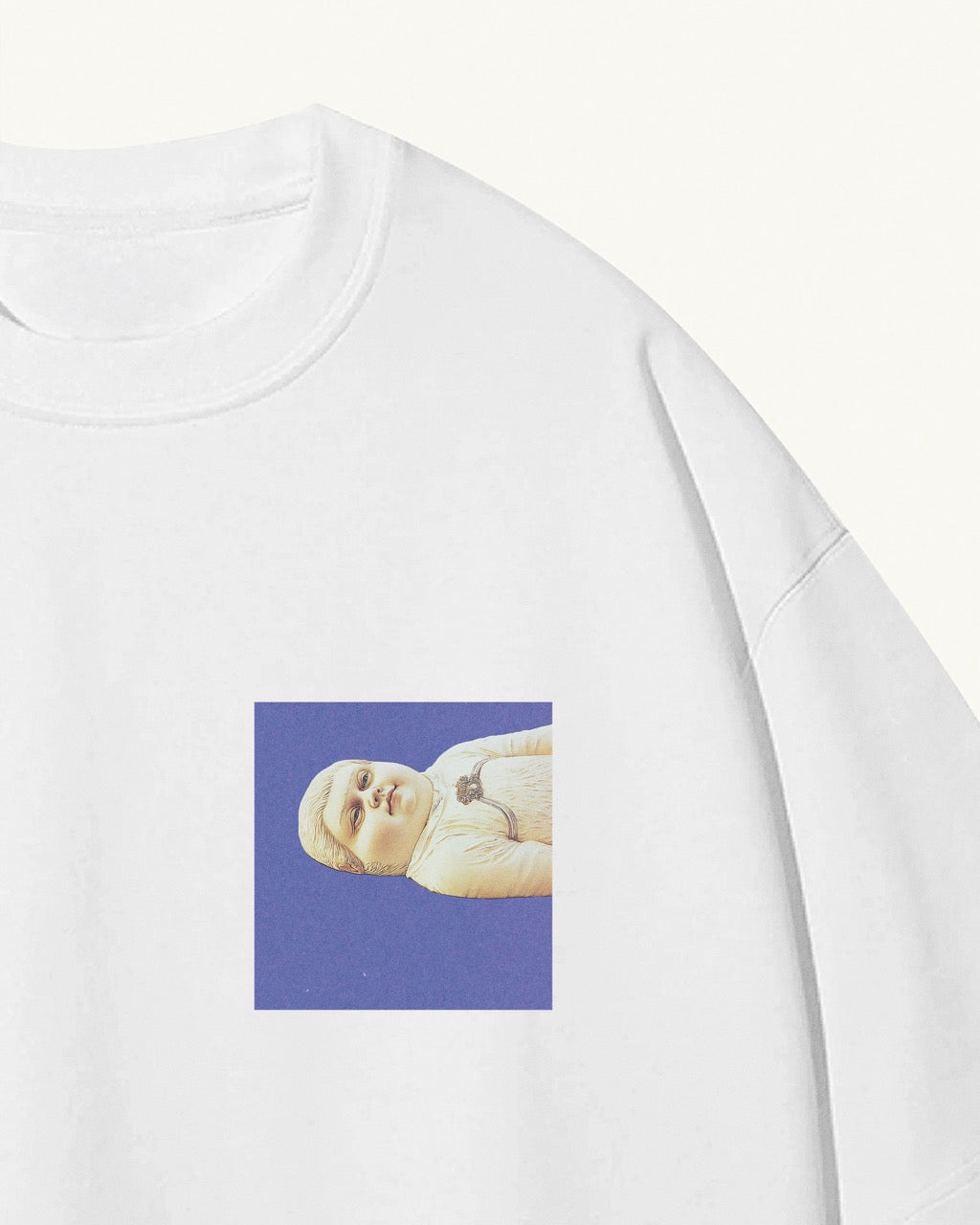 white organic cotton Geoff & Jeffrey, unisex t-shirt with drop shoulders and Geoff lying down on a blue square on the front. The shirt has a minimal design.