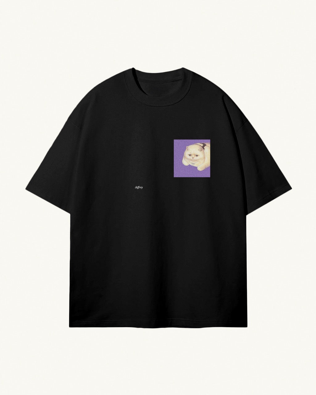 black organic cotton Geoff & Jeffrey, unisex t-shirt with drop shoulders and the funny cat Jeffrey on a purple square on the front. The shirt has a minimal design.