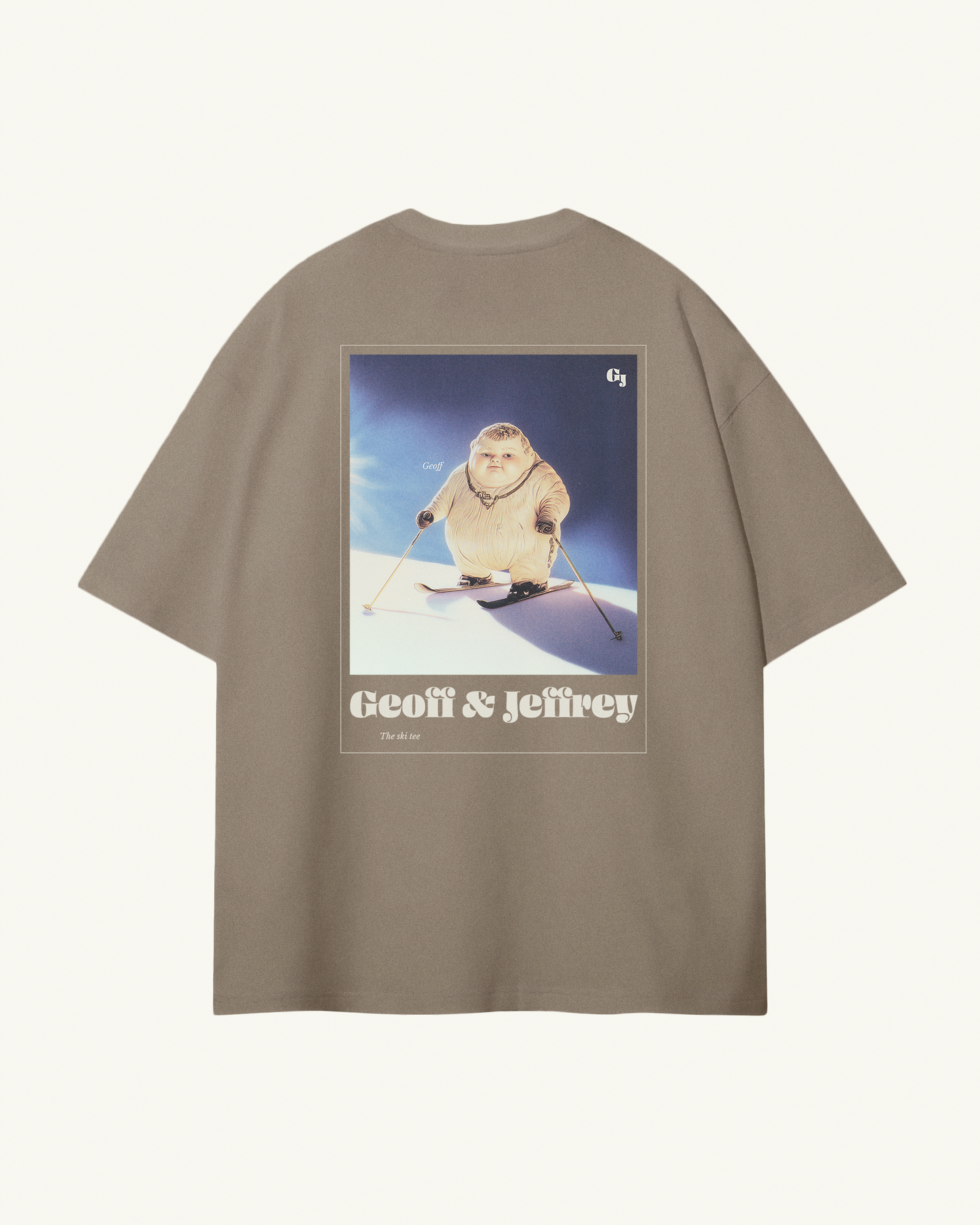 light kaki / brown organic cotton Geoff & Jeffrey unisex t-shirt with drop shoulders  and a large graphic backprint of a joyful, proud boy Geoff skiing, with the brandname and title printed below. The t-shirt has a cool aesthetic.