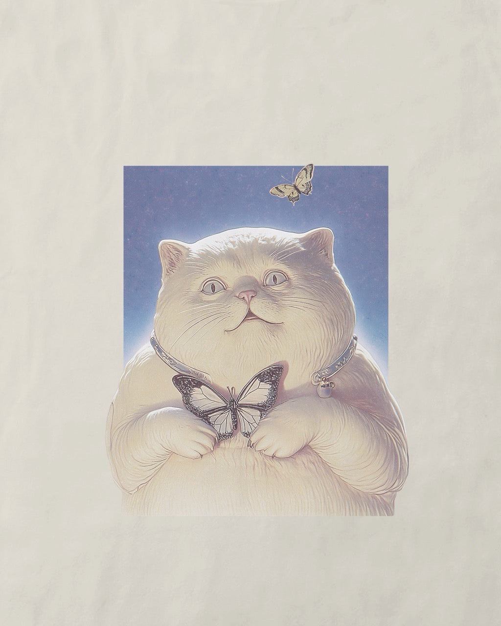 Close up of a women's off-white natural organic cotton Geoff & Jeffrey t-shirt with a small graphic print of a funny fat cat (Jeffrey) holding a butterfly. The t-shirt has a cute aesthetic.
