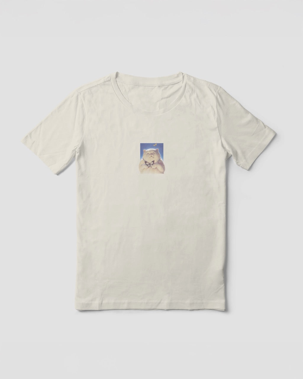 Women's off-white natural organic cotton Geoff & Jeffrey t-shirt with a small graphic print of a funny fat cat (Jeffrey) holding a butterfly. The t-shirt has a cute aesthetic.