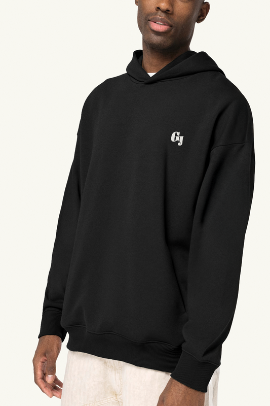 Person wearing a black hoodie with the small Geoff & Jeffrey logo on front